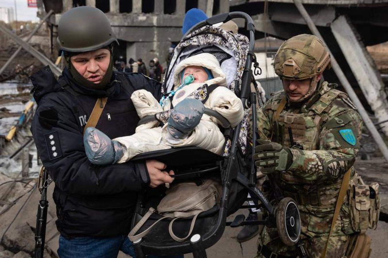 Los militares cargan a un bebé durante la evacuación de residentes en Irpin.