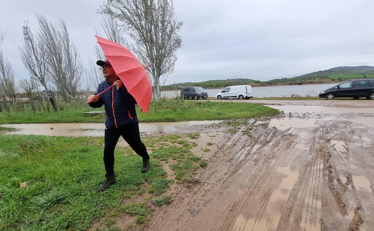 Un hombre se protege de la lluvia el miércoles pasado al lado del río Guadiana en Mérida, en El Prado. 