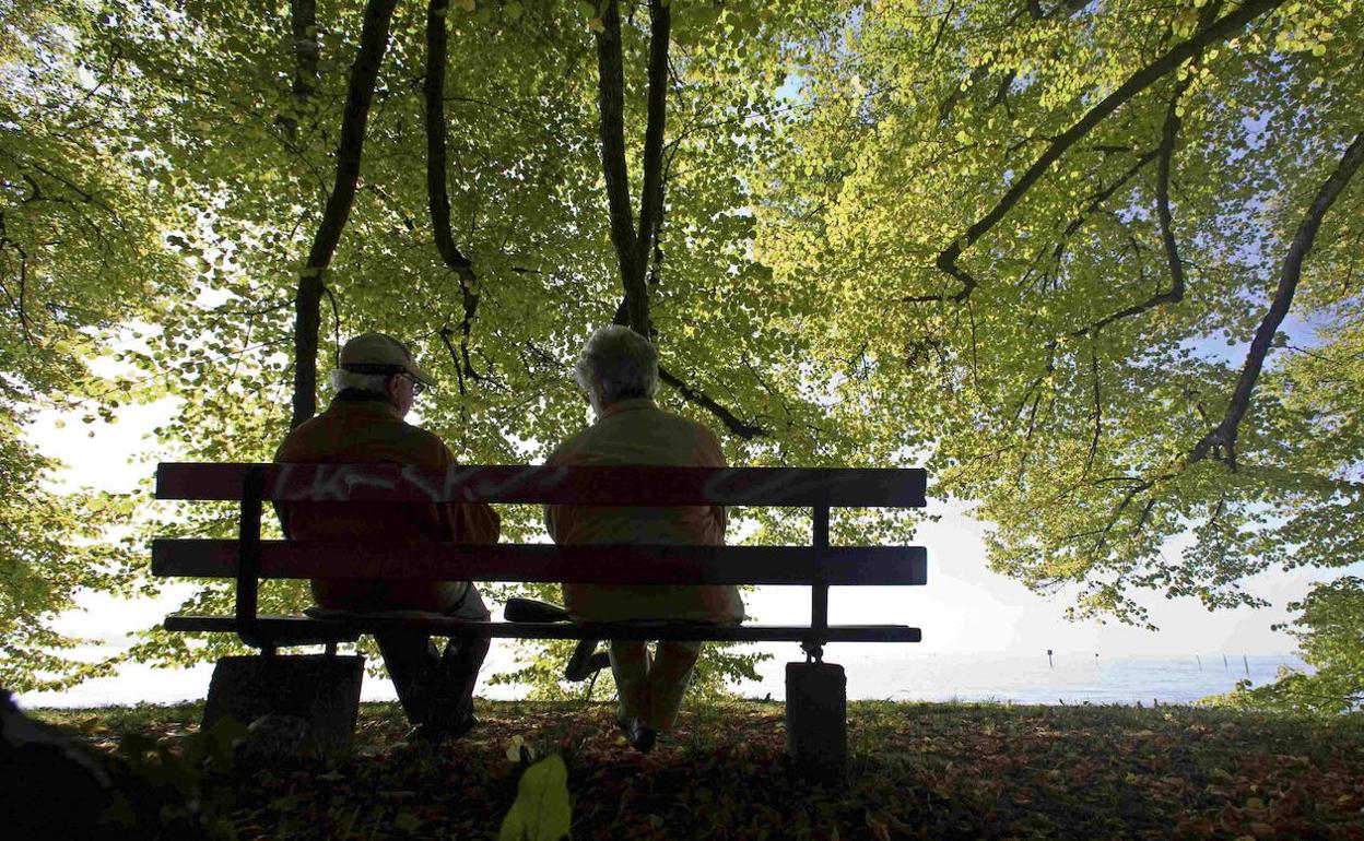 Personas mayores sentadas en un banco.