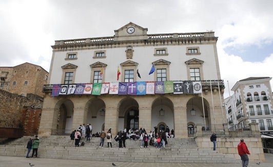 Los pendones de las 17 cofradías de Cáceres cuelgan del balcón del Ayuntamiento. 