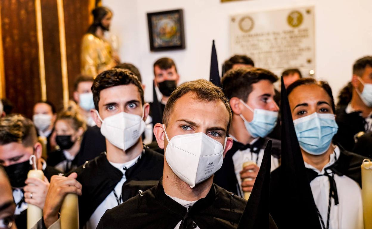 Nazarenos con mascarilla en Sevilla.