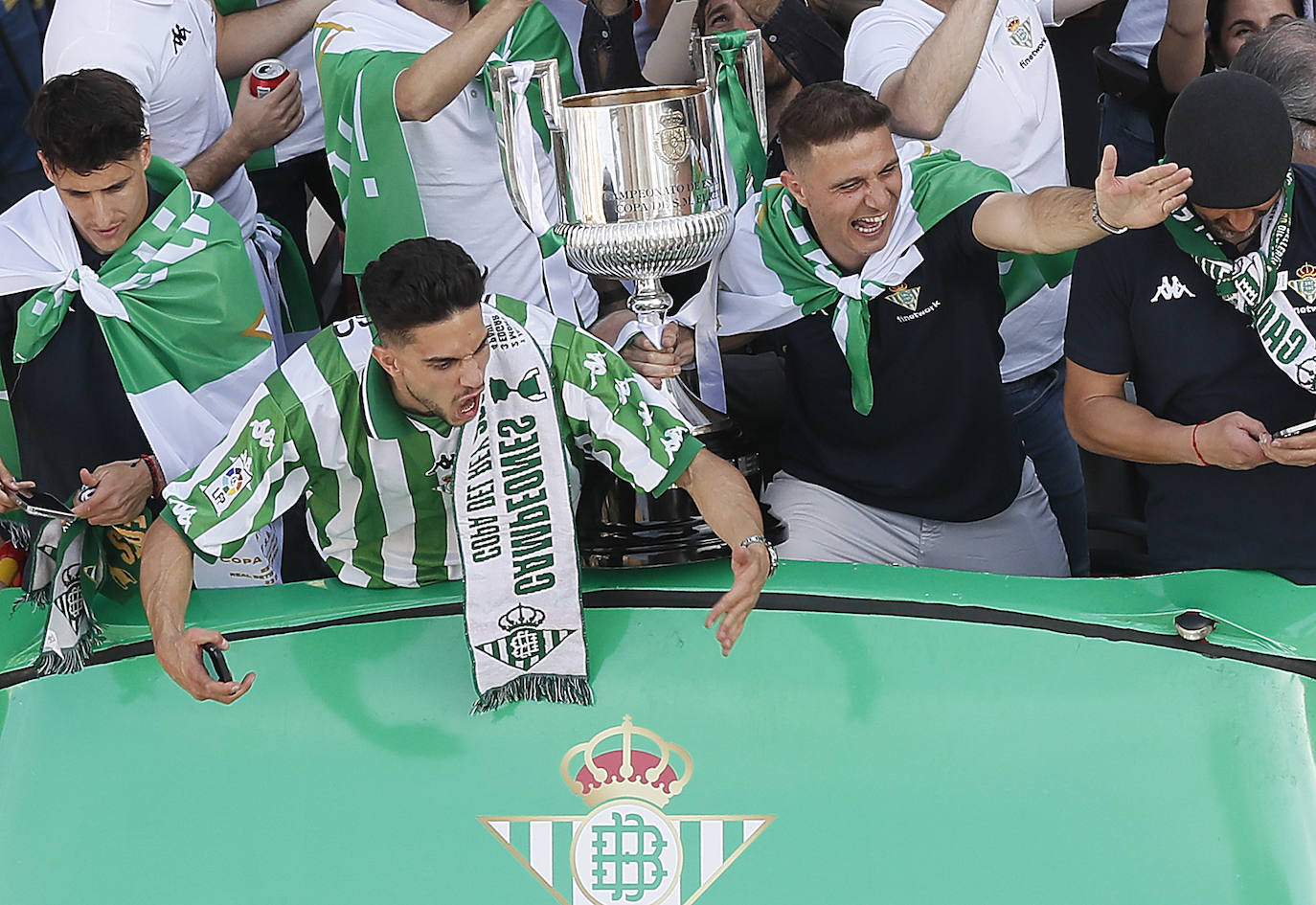 Marc Bartra y Joaquín saludan a la multitud que sigue al autocar del equipo bético durante su recorrido por la Avenida de la Constitución con destino al ayuntamiento de Sevilla, para celebrar su título de Copa del Rey.