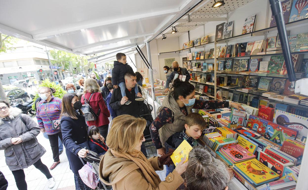 Los lectores abarrotan los puestos de las librerías instalados en el Paseo de Cánovas.