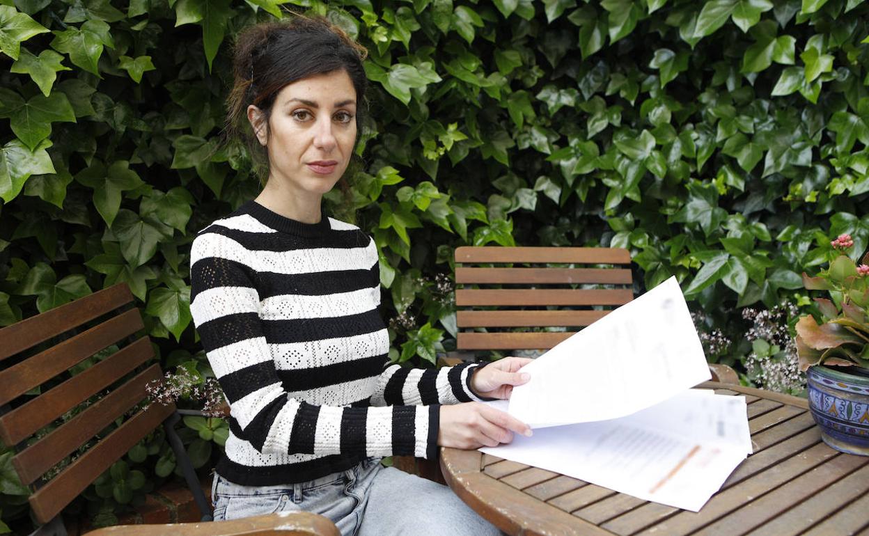 Estrella muestra, desde el patio de su casa en Cáceres, los informes médicos que tiene del último año. 