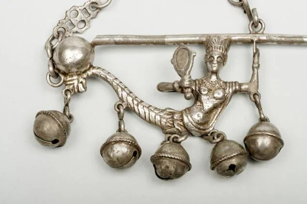 Sonajero de plata del siglo XVII que se utilizaba en Extremadura para que los niños que lo llevaban no se murieran. Es una sirena coronada ante un espejo, que además de cascabeles tiene un silbato. 