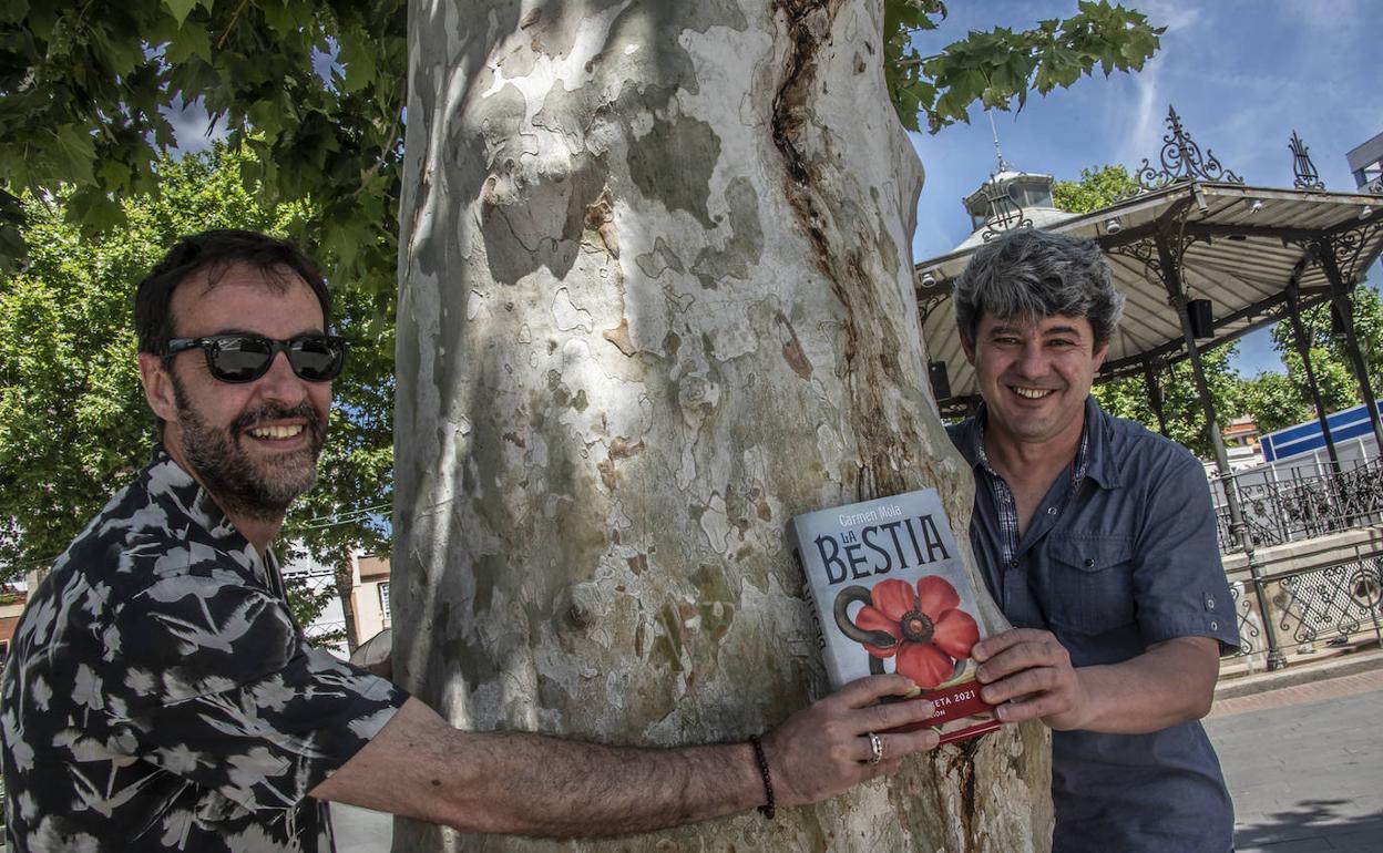 Agustín Martínez y Antonio Mercero sujetan un ejemplar de su libro 'La Bestia' en el paseo de San Francisco. 