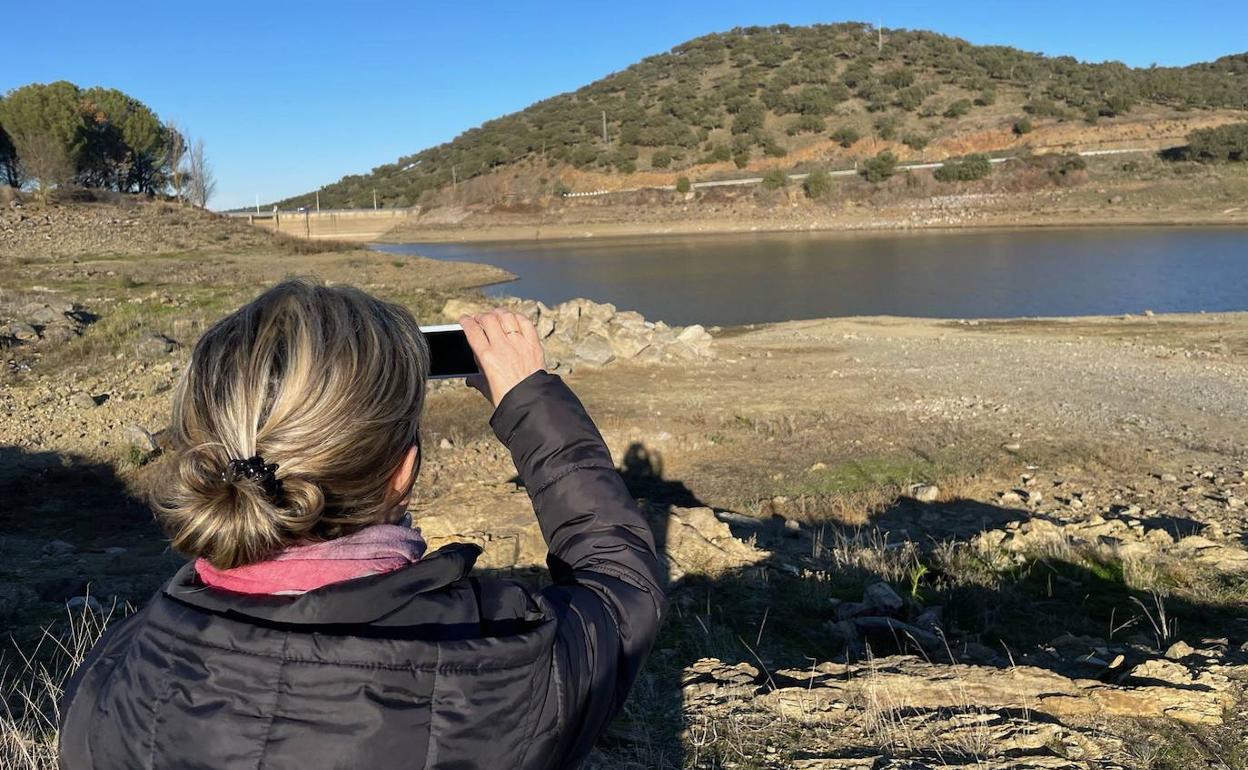 Una mujer hace una fotografía a la presa de Tentudía el diciembre pasado. 