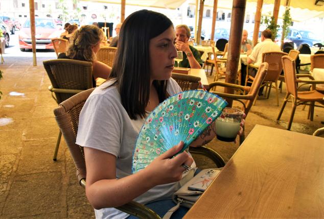 Una mujer utiliza un abanico para luchar contra el calor en Trujillo.