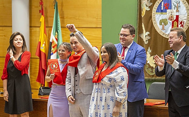 César Silva, en el momento de la imposición de la beca, junto a dos de sus compañeras de promoción. 