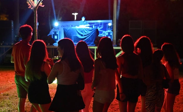 Un grupo de menores, frente al escenario de la caseta joven de La Isla.