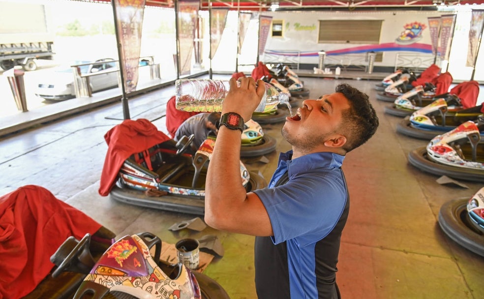 Un trabajador de la pista de Julio Naranjo refrescándose con agua este lunes en el ferial de Caya. 