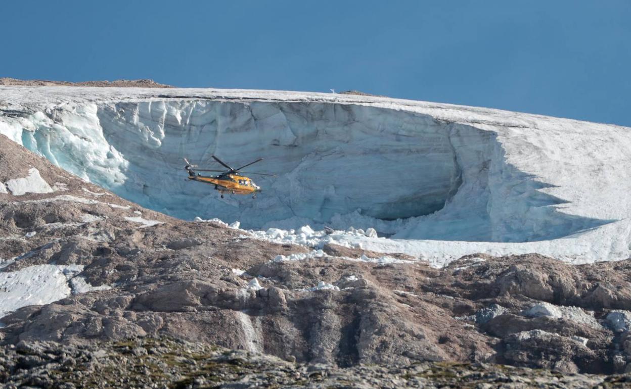 Un helicóptero policial sobrevuela el glaciar Marmolada tras el accidente. 