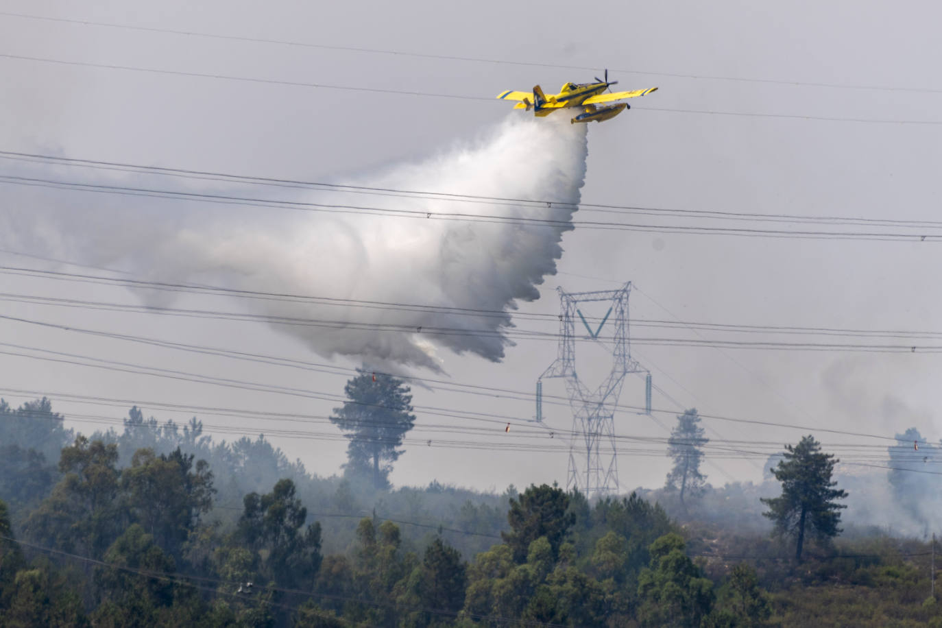 Avión de bomberos arrojando agua en las labores de extinción