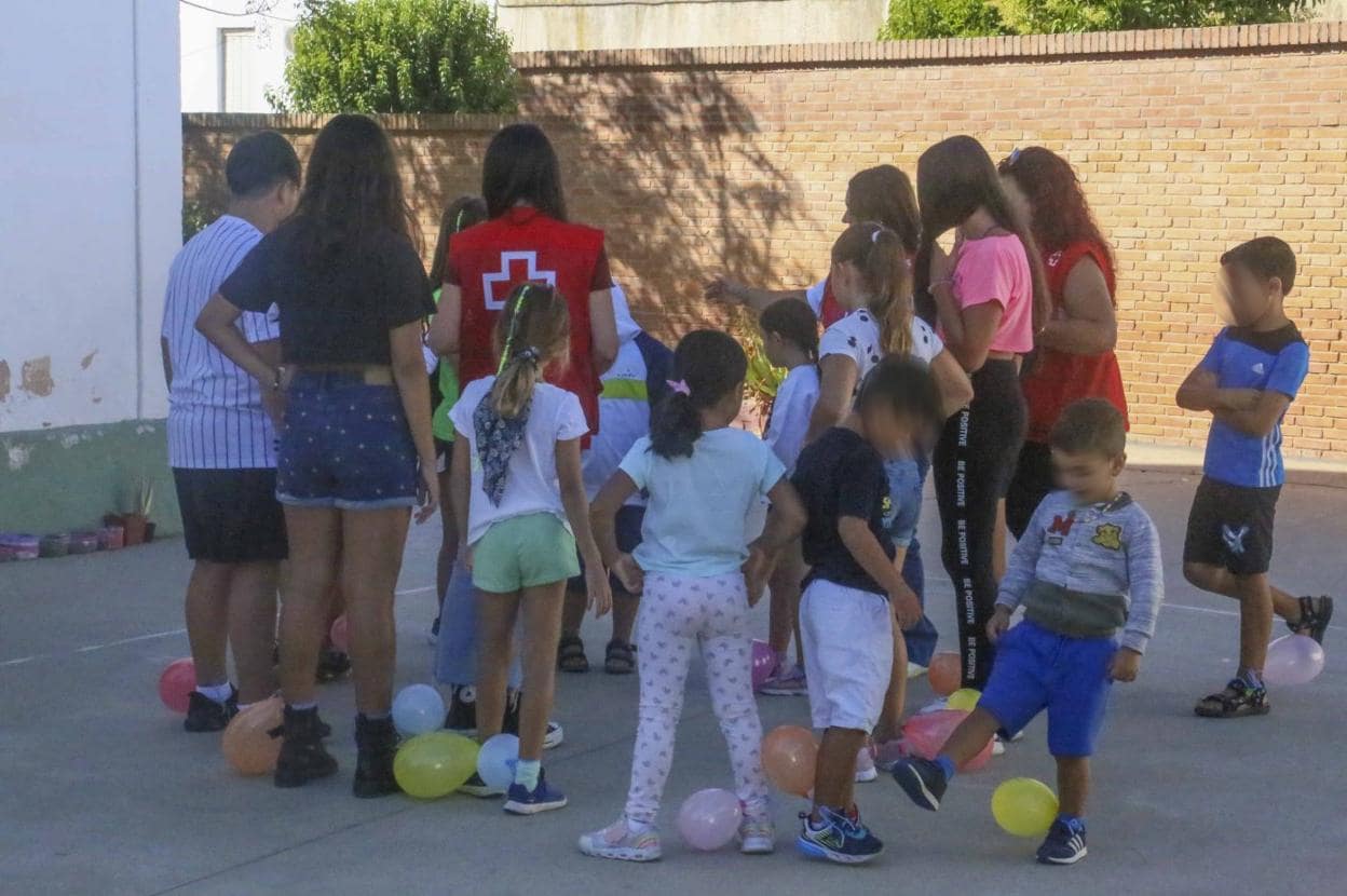 Niños que participan en el campamento junto a sus monitoras, ayer en el colegio García Lorca. 