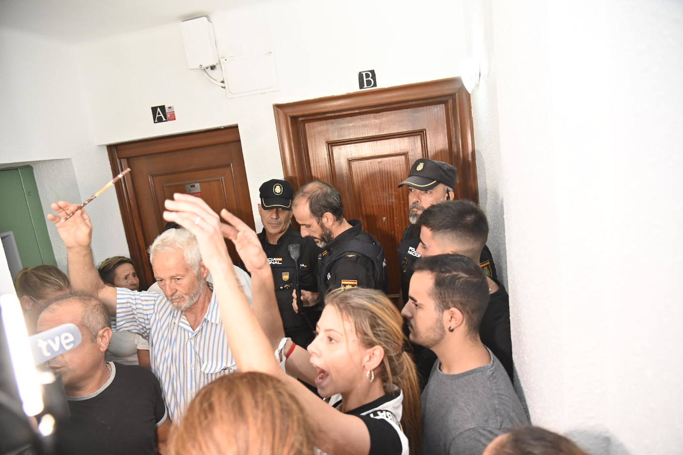 Vecinos protestando anoche en el rellano del piso okupado en Badajoz. 