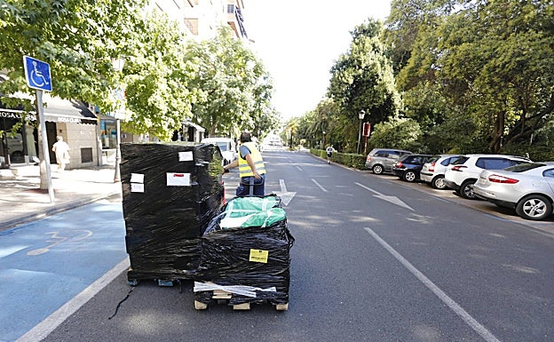 Un repartidor con su mercancía en la calzada de la avenida de España. 
