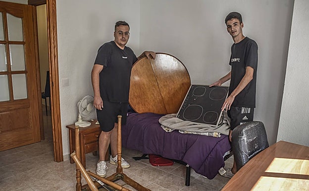 Rodrigo Valdés y Pablo Pérez muestran la vitrocerámica y el tablero de una mesa que iban llevarse junto a las patas desmontadas de ésta. 