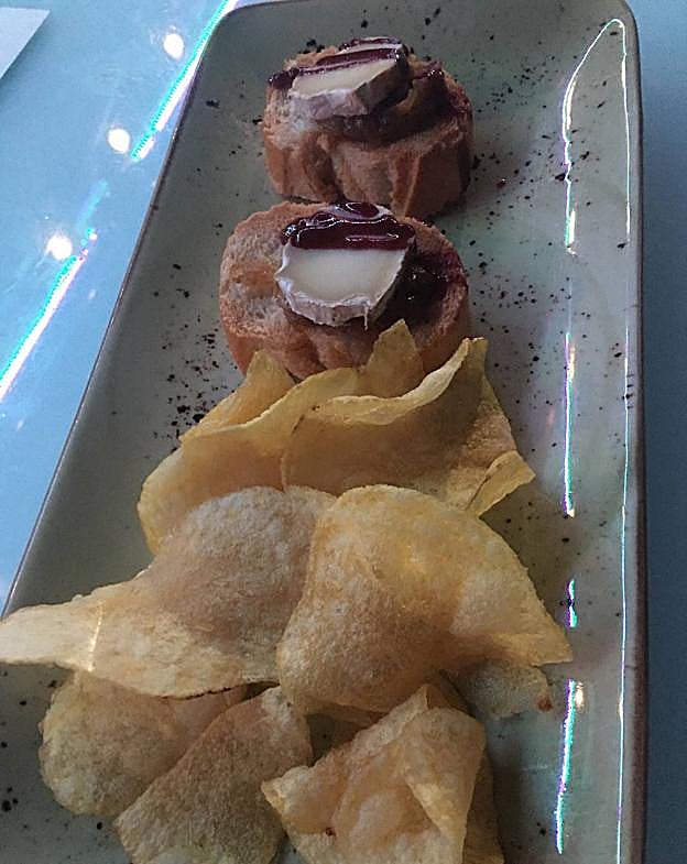 Aperitivo de cortesía: rulo de cabra y patatas fritas.