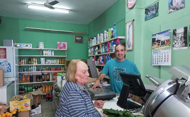 Juan Arturo Martínez atiende a una clienta en su tienda de San Roque. 