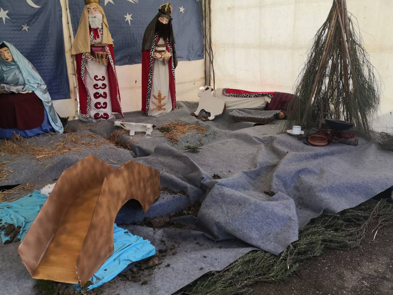 Imagen principal - aArriba, estado en que apareció en la mañana del domingo el Belén. Abajo, la carpa ya sin el Belén retirado por las mujeres de 'Amanecer'; a derecha, árbol de Navidad que han elaborado este año. 