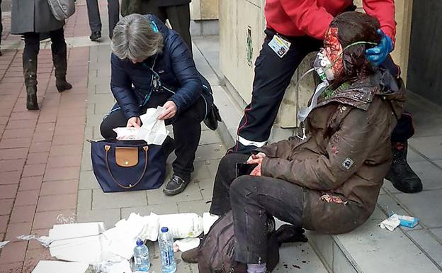 Un agente de seguridad auxilia a una víctima del atentado en el metro de Maalbeek, Bruselas. 