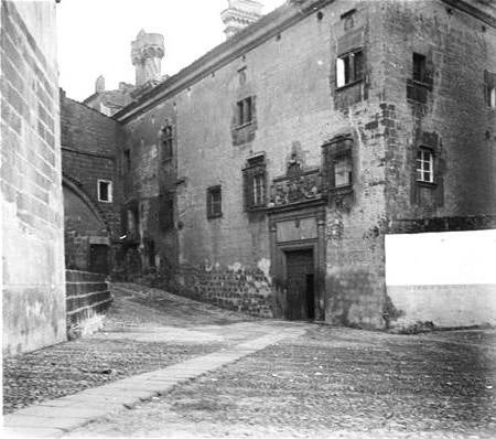 Fachada del Palacio Episcopal de Plasencia, con un muro a la derecha.