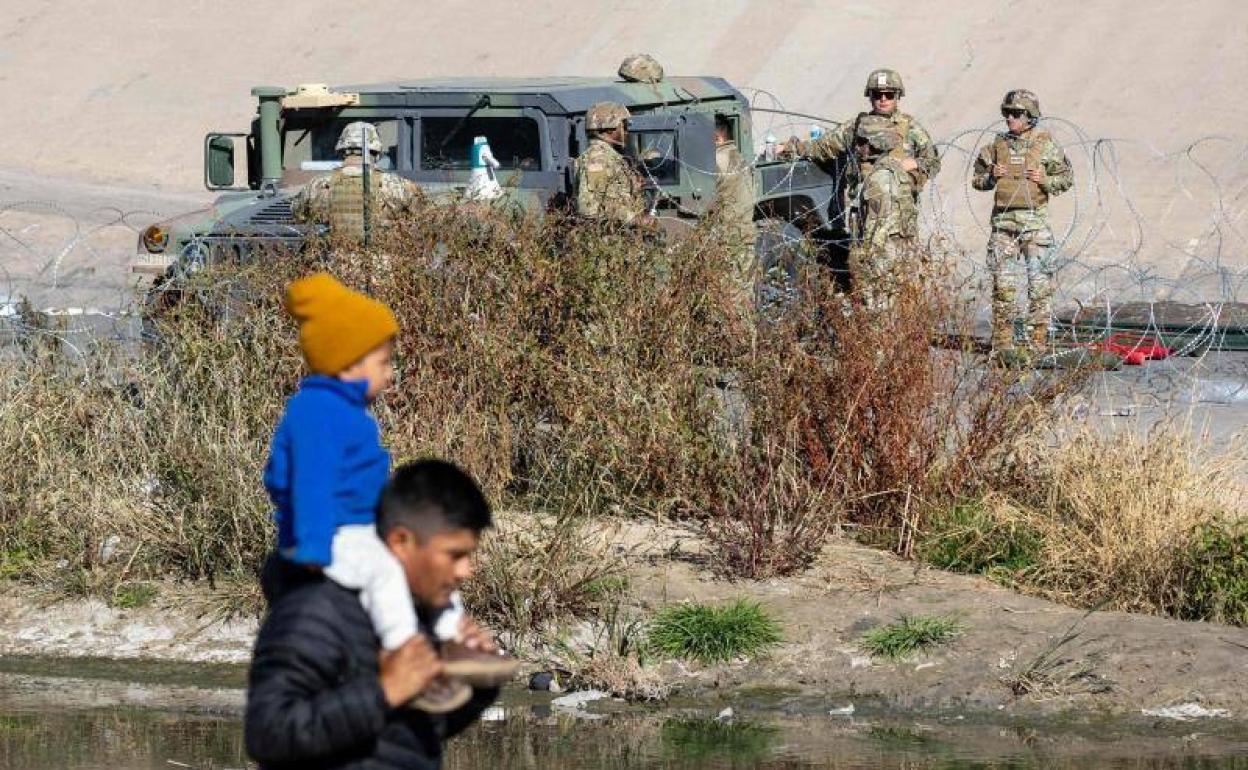 Militares estadounidenses observan desde la otra orilla del Río Bravo a los migrantes latinoamericanos agolpados en el lado mexicano de la frontera.