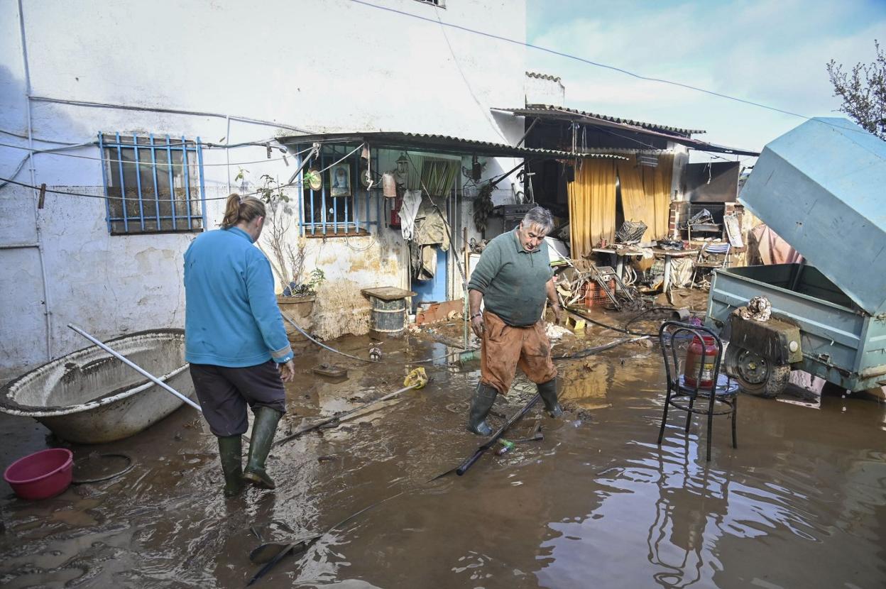 Dos vecinos de Gévora achican agua en su vivienda inundada el 13 de diciembre. 