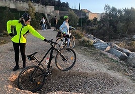 Una ciclista enseña el socavón junto a la pasarela de entrada.
