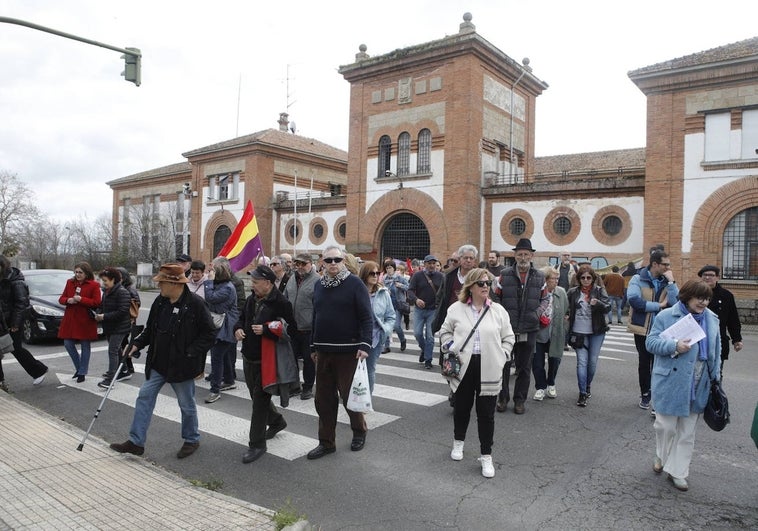 Participantes en el homenaje a todas las víctimas y personas represaliadas por el franquismo en la ciudad de Cáceres, celebrado este sábado, con el edificio de la cárcel vieja de fondo.