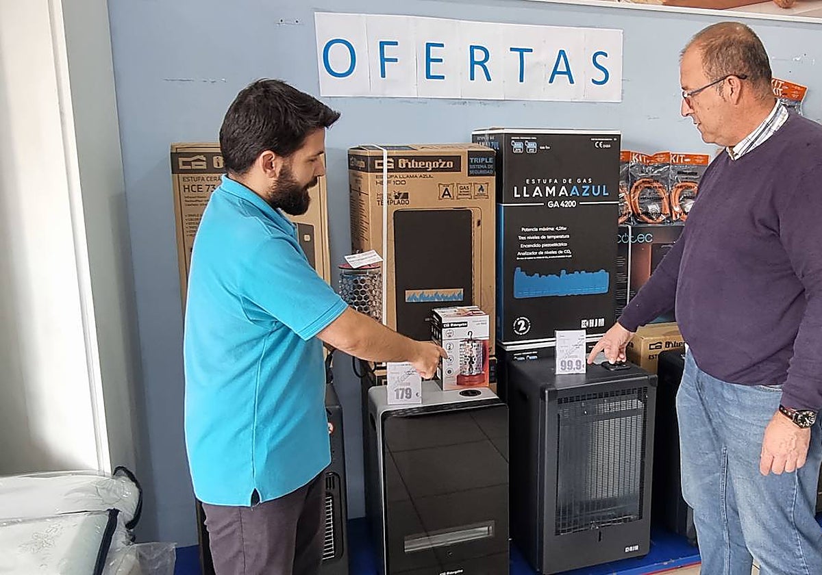 Una persona consulta en una tienda sobre estufas en venta.