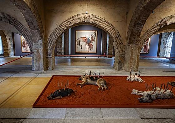 En la instalación'Los fuegos' se ve a unos perros disecados sobre un manto de pimentón de los que nacen cuchillos.