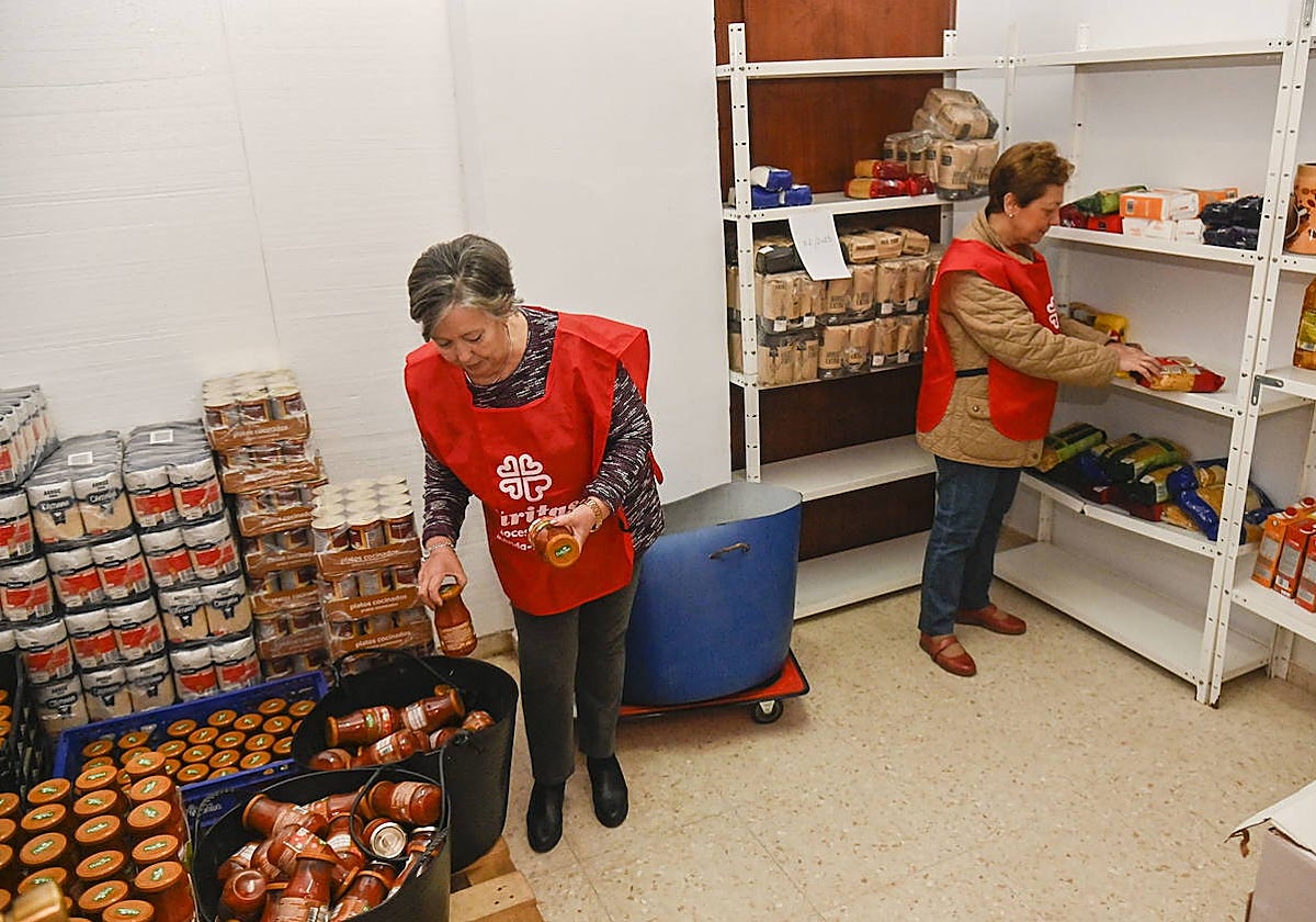 Rosa Infante y Lola Duarte, voluntarias de Cáritas, en el almacén donde distribuyen ayuda en San Roque.