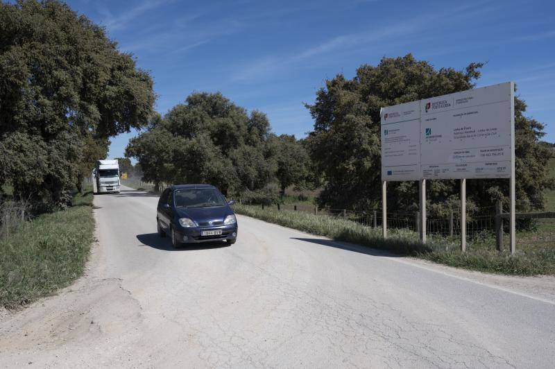 Un conductor circula junto al cartel que informa de las obras de la nueva línea.