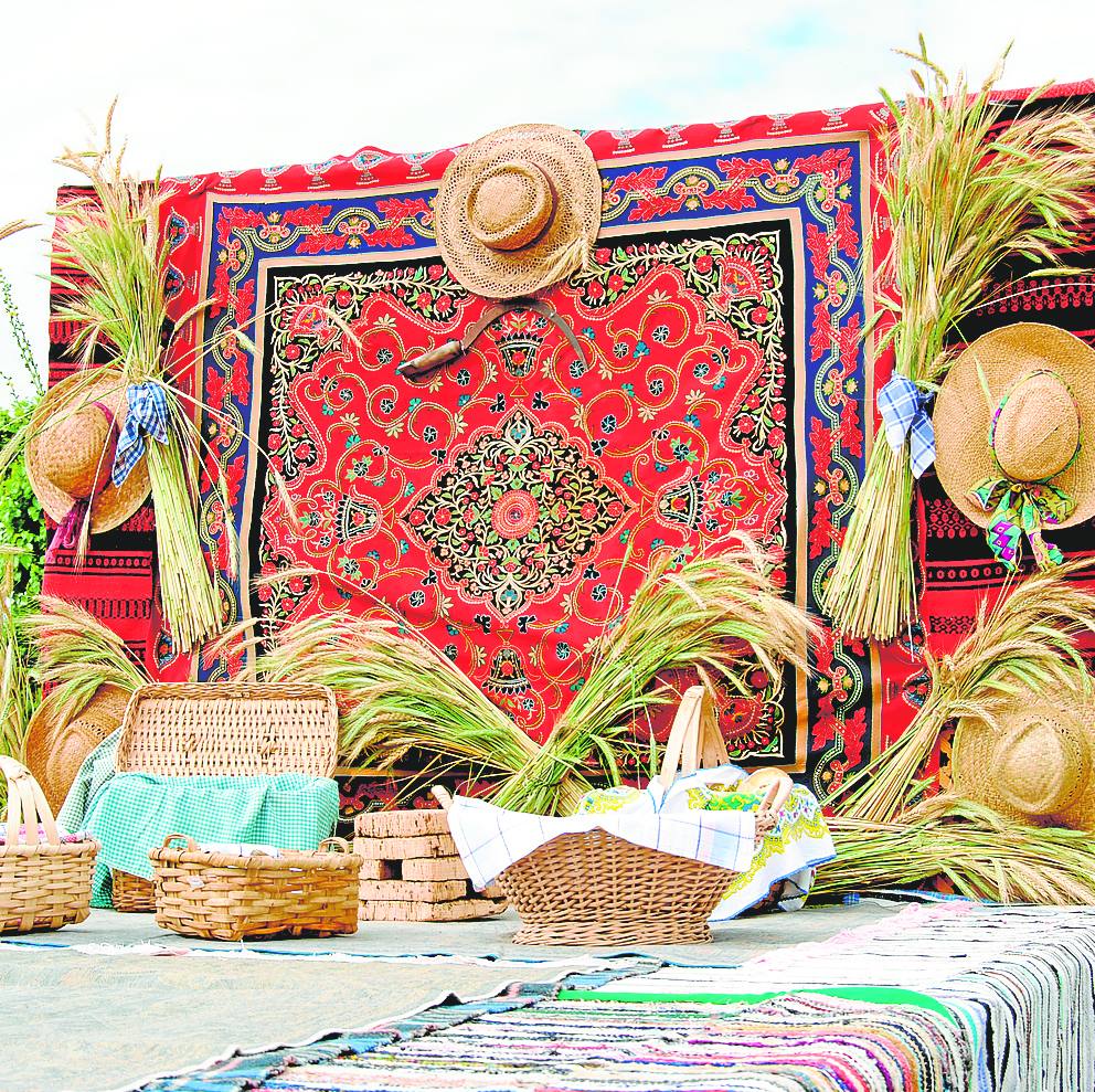 Las carrozas se visten con elementos tradicionales como el mantón y las espigas.