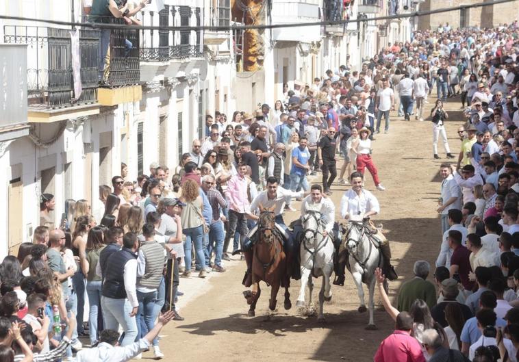 Tres jinetes cruzan La Corredera ante el numeroso público que no se ha querido perder el Día de la Luz.