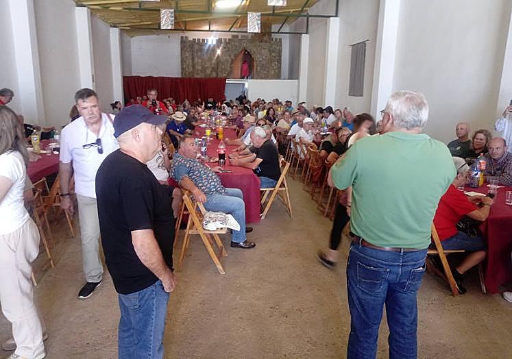Imagen principal - Arriba, el alcalde de Alconchel, mientras se dirige a los participantes en el encuentro. Abajo, regalos intercambiados y Miguel Ángel Castellano, en cargado de cocinar los garbanzos para los visitantes.