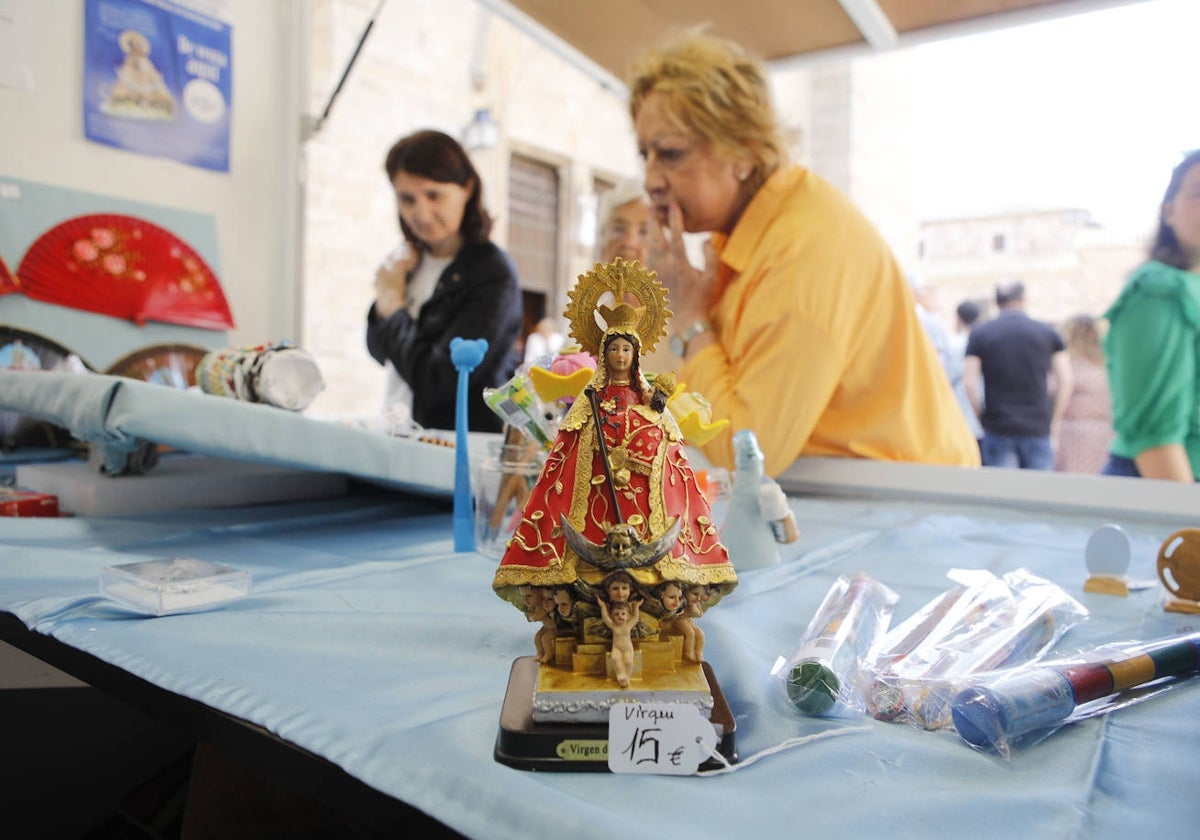 Una mujer se fija en los objetos del puesto instalado junto a la Concatedral con recuerdos de la Virgen de la Montaña.