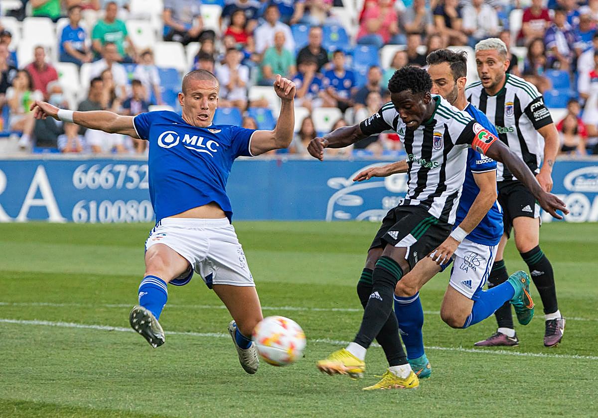 Adilson dispara a portería ante la oposición de Lolo.