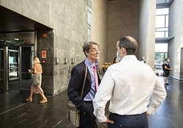 El policía nacional de espaldas junto a su abogado Ángel Luis Aparicio.