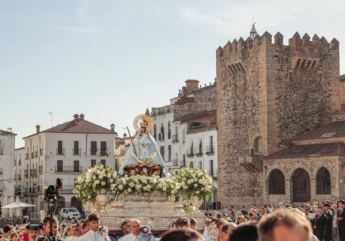 La Virgen de la Montaña, con la Torre de Bujaco de fondo, a su paso por la Plaza Mayor este domingo por la Mañana.