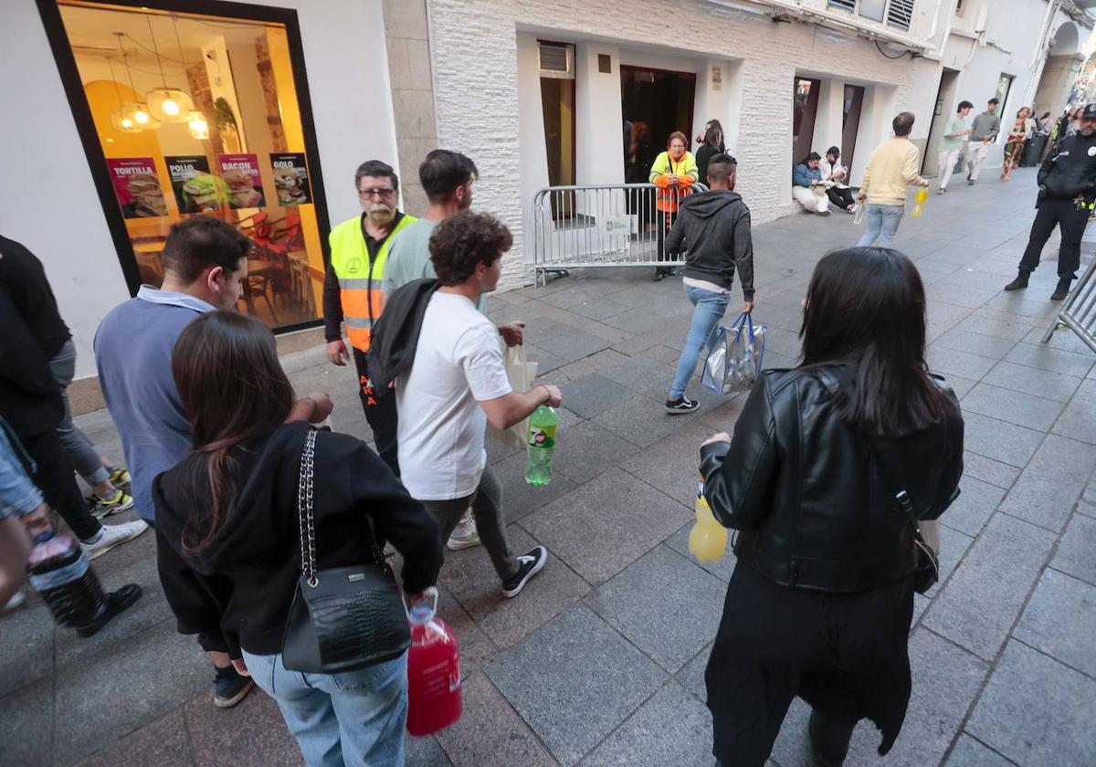 Jóvenes accediendo a la Plaza Mayor de Cáceres con sus bebidas.