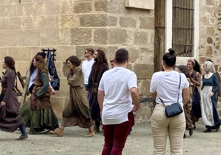 Dos turistas contemplan este martes a un grupo de figurantes a su paso por la plaza de Santa María.