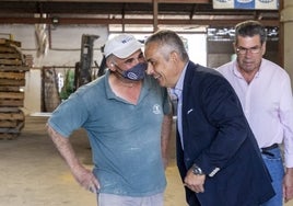 Pelayo Gordillo charla con un trabajador de Copal, ayer en Coria. Junto a ellos, el presidente de la cooperativa.