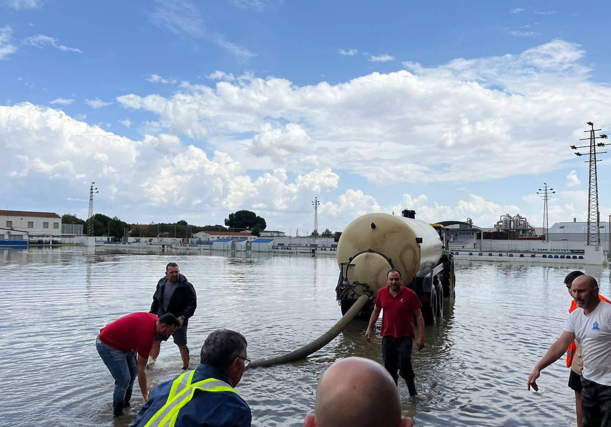 Operarios achicando agua este viernes en la ciudad deportiva de Puebla de la Calzada.