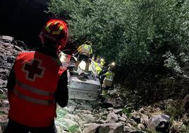 Un efectivo de Cruz Roja observa los trabajos de los bomberos para rescatar los cuerpos del Opel Vectra siniestrado.