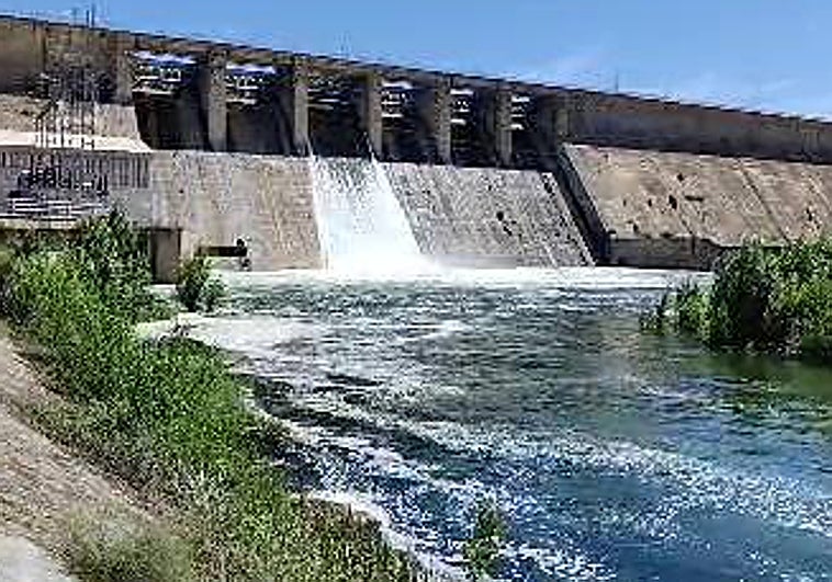 Una de las compuertas de la presa de Orellana suelta agua al río, esta mañana.