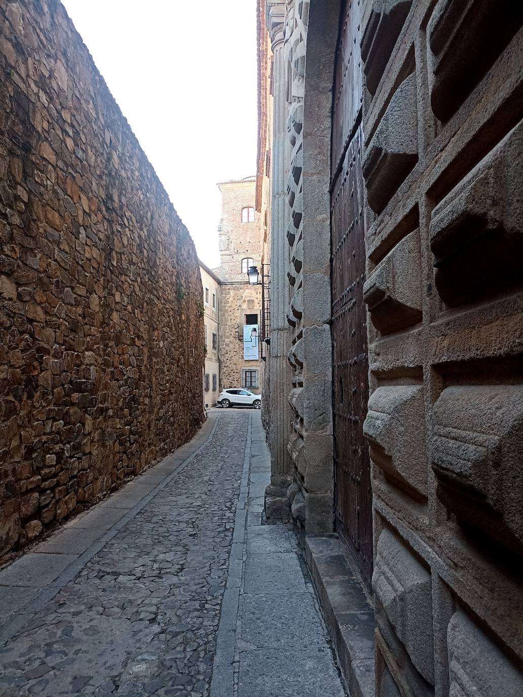 Está en el adarve, entre la Torre de Bujaco y el Palacio Episcopal.
