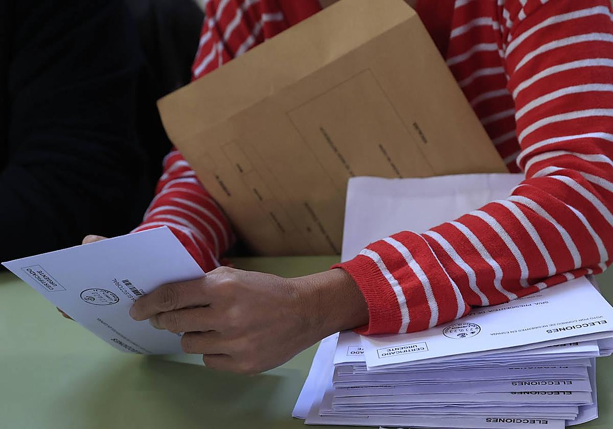 Un miembro de una mesa electoral procede al recuento de votos, tras el cierre de su centro electoral