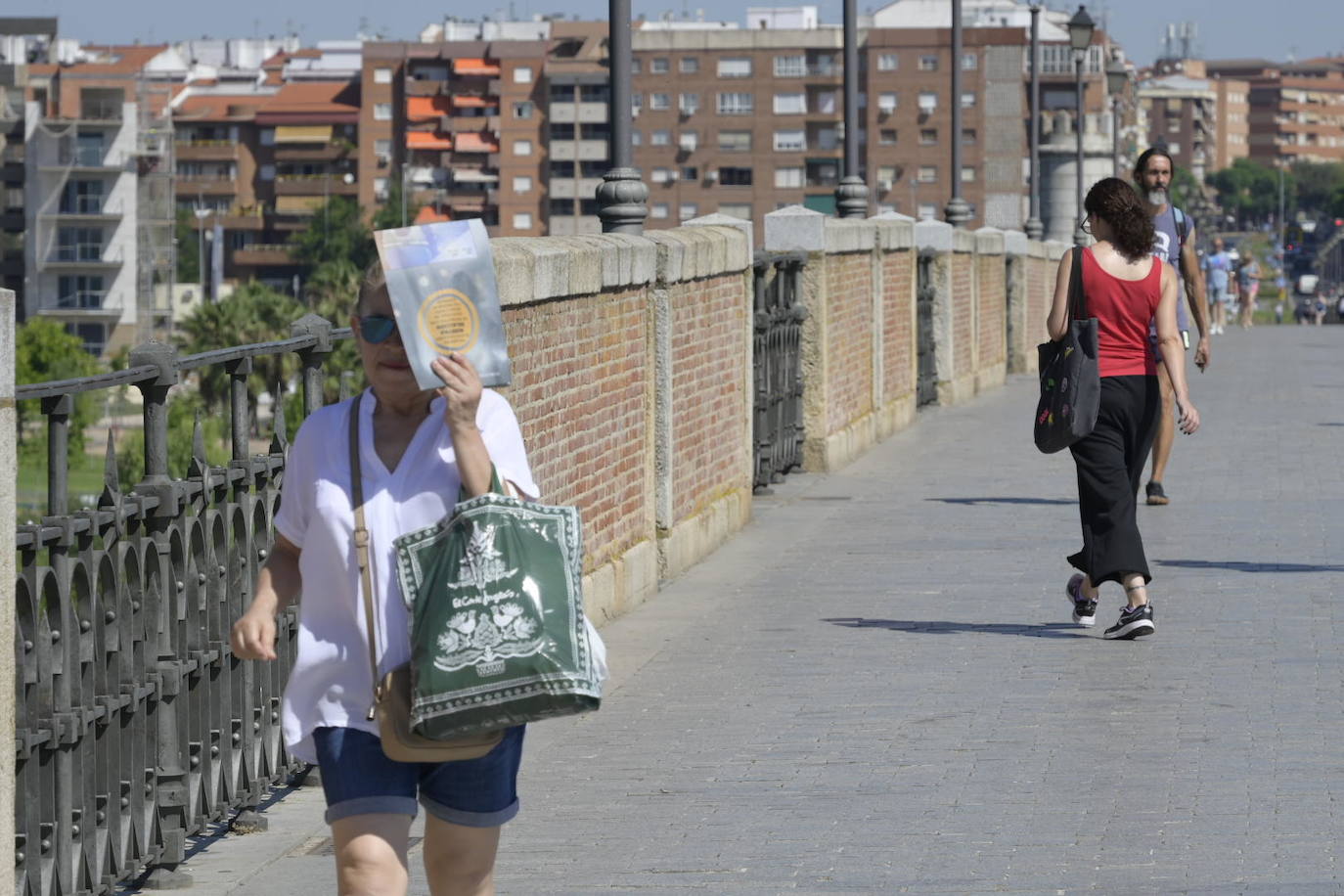 Los pacenses se tapan del sol por el puente de Puerta Palmas